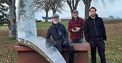 På bilden från vänster syns Mats Nilsson, konsthantverkare från Sölvesborg, Robert Harding, konstnär och Timsam Harding, konstnär, stående vid en av Robert Hardings skulpturer vid Svalövssjön.